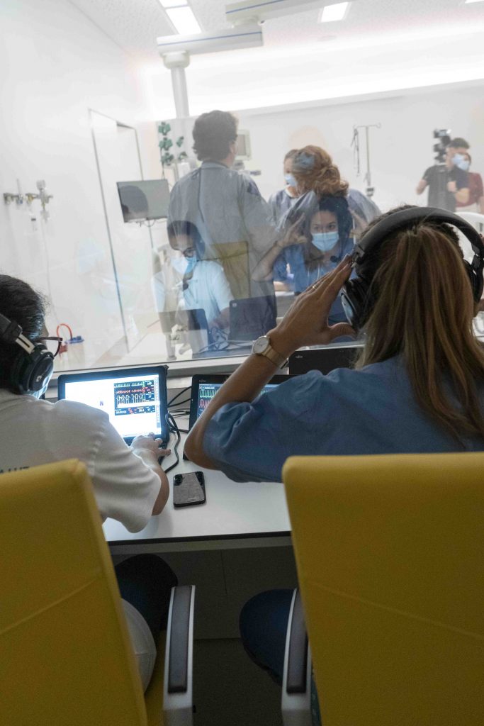 Una instructora observa la simulación a través del cristal